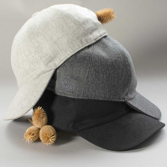 Three cashmere caps in light grey, dark grey and black, with subtle tone-on-tone lion branding.