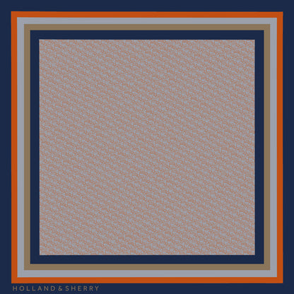 Lion-logo patterned scarf with Holland & Sherry branding with a dark blue, orange, grey and gold border.